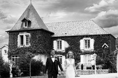 Couple de mariés se tenant la main au domaine du Feyel dans les Vosges, photographie en noir et blanc