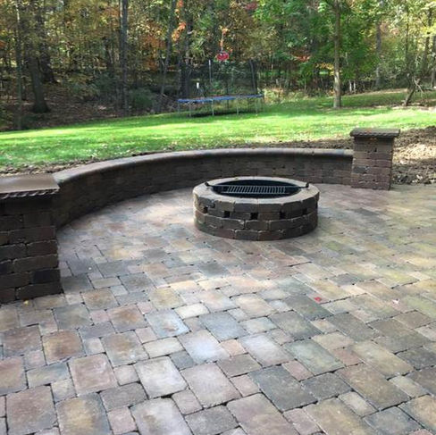 paver system backyard patio, featuring a firepit and curved wall for seating