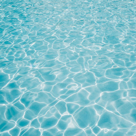 Rippling blue water in a swimming pool, sunlight reflecting off the surface—calm, inviting, and full of possibility.