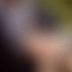 The groom's mother pins his maroon corsage to his jacket