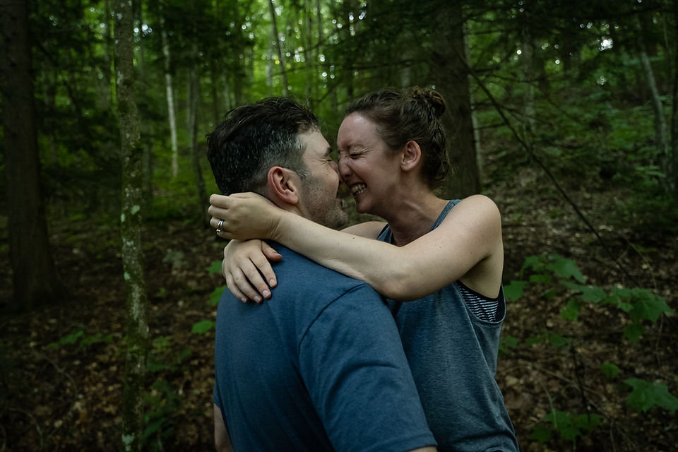 A couple laughs and kisses during their outdoor adventure engagement session with Outdoor Chronicles Photography. Great Barrington Massachusetts.