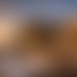 Luxury home under construction in the Texas Hill Country at sunset, featuring modern stone and steel architecture, large glass windows, architectural plans and tools in the foreground—representing luxury construction in Texas and custom luxury home design near San Antonio.