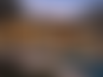 Modern Texas Hill Country luxury home at twilight featuring limestone walls, expansive floor-to-ceiling glass, open-concept interior, and resort-style pool terrace. Elegant contemporary architecture reflecting refined Luxury Construction in Texas and bespoke custom home design in San Antonio and the Texas Hill Country.