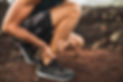 Achilles injury on running outdoors. Man holding Achilles tendon by hands close-up and suf