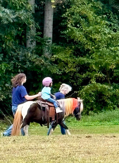 Child enjoying mobile pony ride