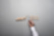 Man drawing the outline of a businessman stopping the domino effect in a conceptual image