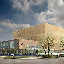 A low rectangular building with a gold trapezoidal tower sits at the corner of two streets.