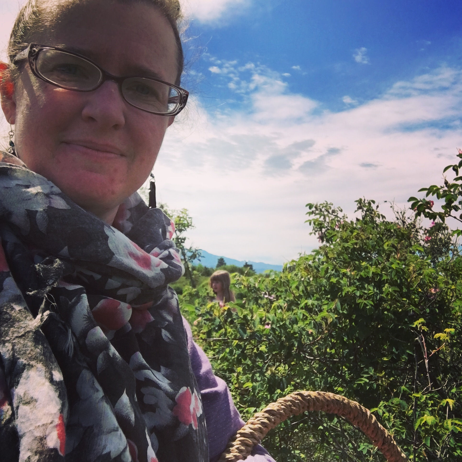 Woman with a basket in a rose thicket