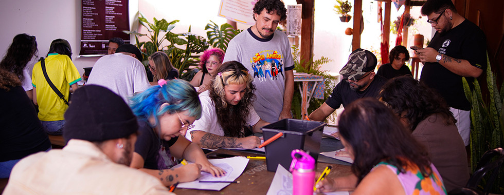 Participante recortando matriz de stencil de cachorro durante oficina de arte urbana no Instituto Casa Valenta, Goiânia.