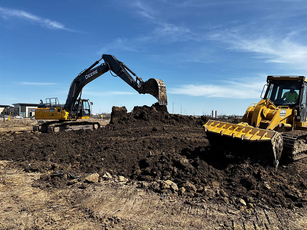 Excavator digging dirt next to a bulldozer