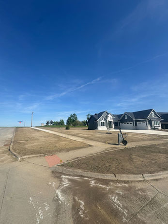 Residential neighborhood with houses under construction and a clear blue sky.