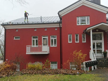 Talokas Oy:n kiinteistöhuoltaja katolla putsaamassa rännejä