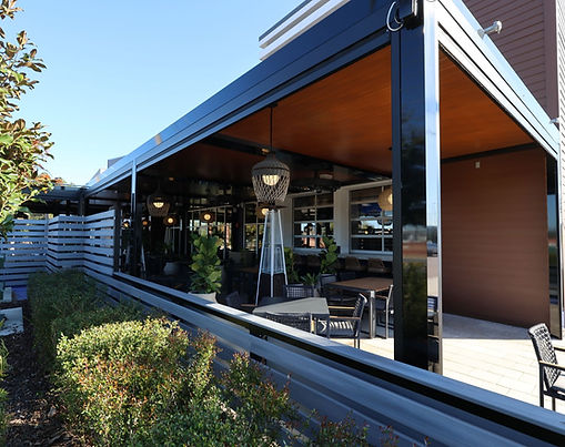 Insulated AV Composites patio roof providing deep, cool shade over a luxury residential outdoor living space.