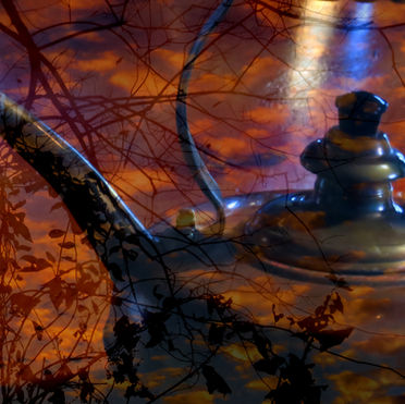 Surrealistic photo of a copper tea kettle amid clouds in the sunset and reddish-brown silhouettes of branches.