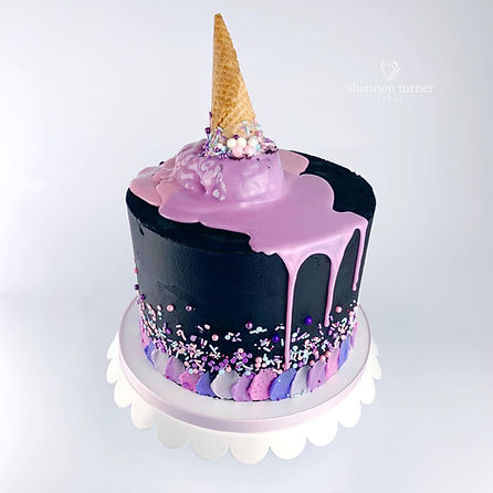 Black buttercream cake with bright pastel buttercream palette knife details around the bottom of the cake in pinks, purples, and whites, with a bright colorful sprinkles fade and pink white chocolate drip and melting ice cream cone accent on top