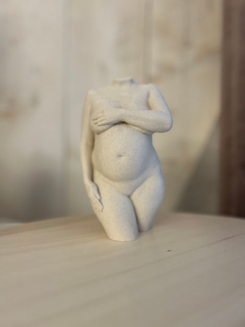 Sculptuur van een zwangere vrouw die haar buik bedekt. Babycrafts – Jouw Buik in 3D