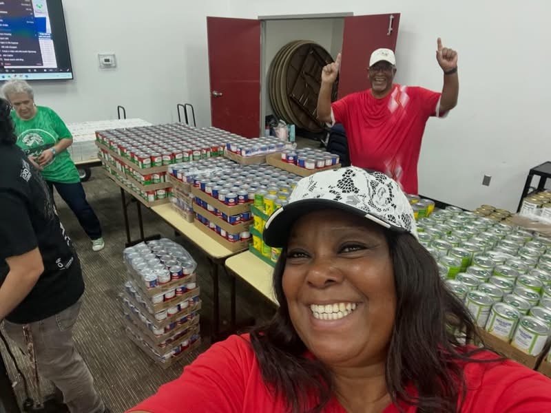 Outreach volunteers with tables of canned food ready for distribution