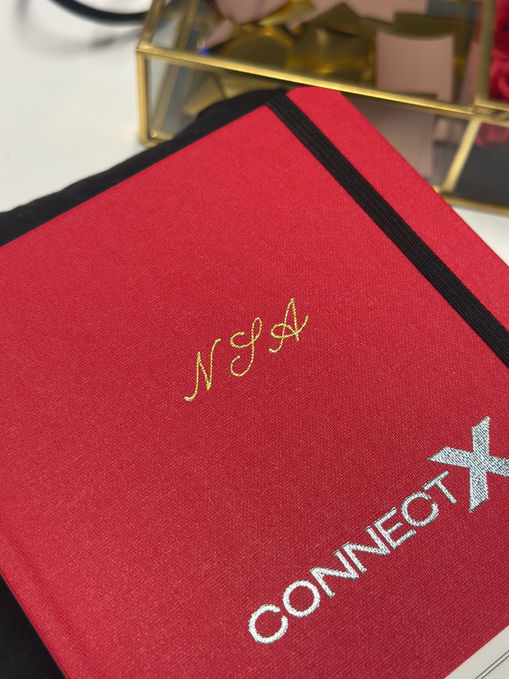 hot foiling calligraphy on notebook covers with corporate event guest names and initials