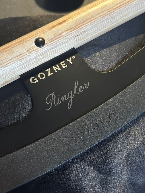 Branded live calligraphy engraving for Gozney in-person event, engraving guests names and initials on pizza rocker