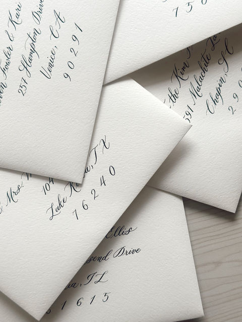 Custom calligraphy envelope addressed in white ink for a high-end wedding invitation suite