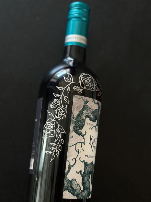 Engraved wine bottles with custom calligraphy and floral illustration for a milestone anniversary gift