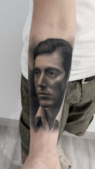 Tatuaje de retrato de Al Paccino interpretando a Michael Corleone en negro y grises. Tatuaje hiperrealista de rostros. Mejor tatuador de realismo en Barcelona, España.
