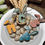 Miniatura: Segnaposto pasquale in legno a forma di coniglietto con iniziali personalizzate in colori pastello su piatto decorativo.