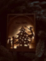 Quadretto luminoso artigianale in legno con scena natalizia di bambini che decorano l’albero, regalo di Natale per maestre.