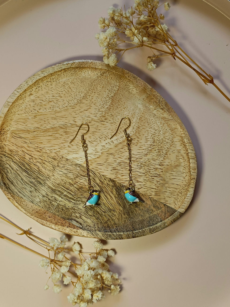 Pendientes largos, terminando en un colgante en forma de pájaro