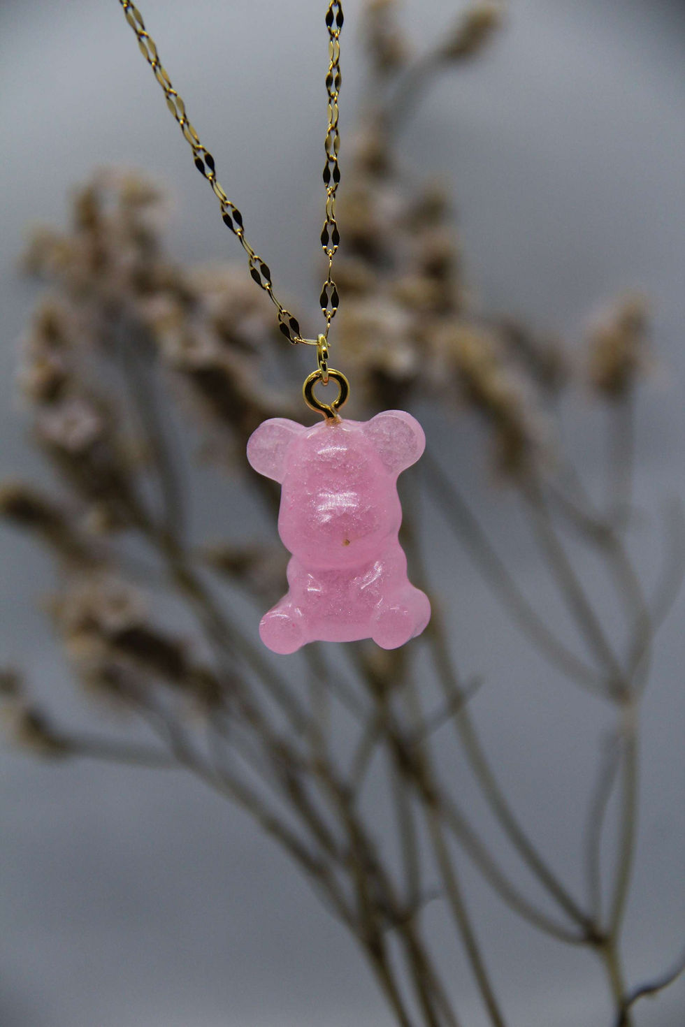 Miniatura: En esta imagen vemos el collar de oso, este de color rosa, con la cadena dorada.
