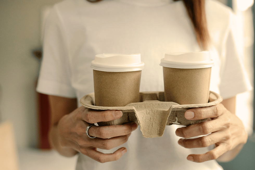 Woman holds two to-go coffee cups