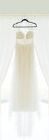 Mallory Cook Creative Photography Romantic white and champagne lace wedding gown hanging in KC area barn