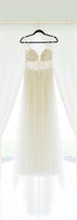 Mallory Cook Creative Photography Romantic white and champagne lace wedding gown hanging in KC area barn