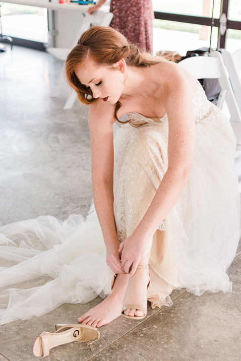 Mallory Cook hosted and coordinated Wedding Styled Shoot Bride putting on heels in champagne and ivory lace gown.