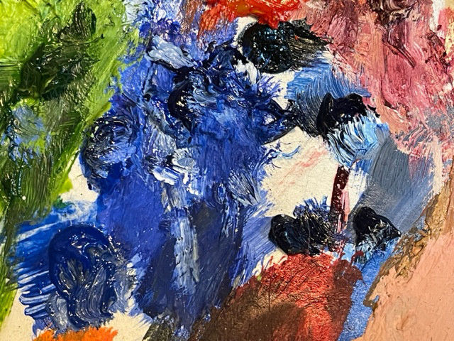 A photo of an oil paint palette with a range of blue paints smeared across it