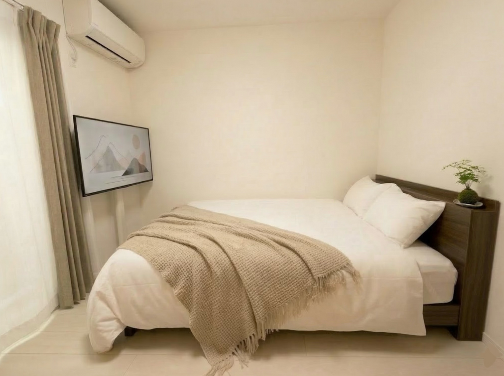 Minimalist bedroom with a double bed and neutral tones in a furnished Tokyo hatsudai expat Apartment Lohus.