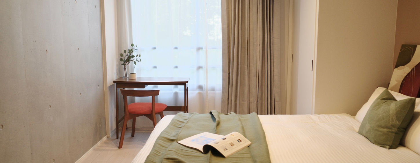 Minimalist bedroom with a double bed and neutral tones in a furnished Tokyo Otsuka expat Apartment Lohus.