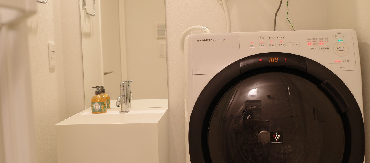 Private in-unit washing machine and laundry area in a furnished serviced apartment in Tokyo.