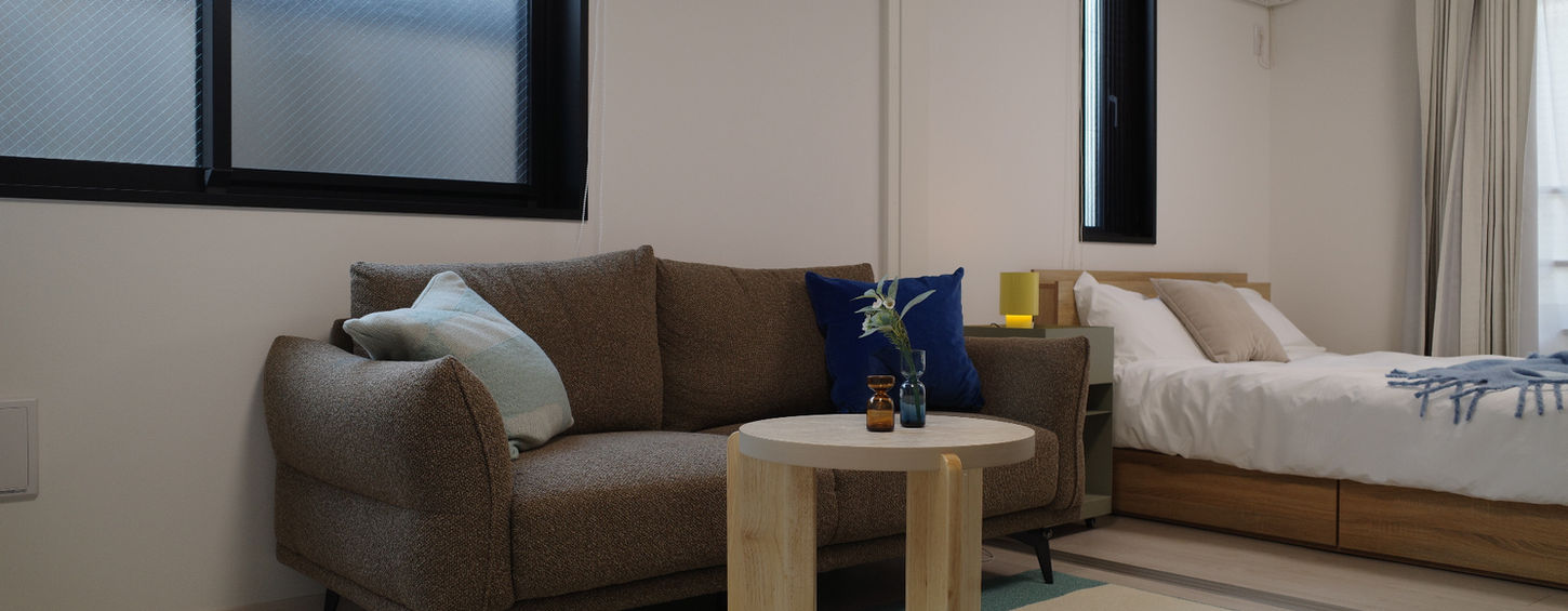 Modern living area with minimalist sofa and natural lighting in a furnished in Tokyo shinjuku central park Apartment Lohus serviced apartment for expats.