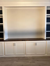 Sleek white wall unit with contrasting navy blue interior shelving and a rich wooden countertop