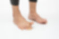 A person standing with their big toes lifted skywards off the ground. This is a type of exercise that might be given for someone with foot pain.