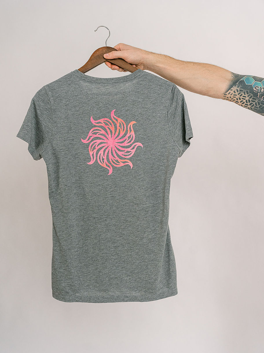 Hand holding grey Decent Threads t-shirt with pink logo design