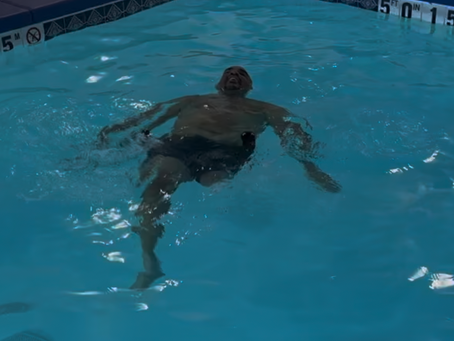 James Gouch, an amputee athlete and founder of Amputees Are Awesome, swimming confidently in a pool, showcasing strength, resilience, and the benefits of adaptive fitness.