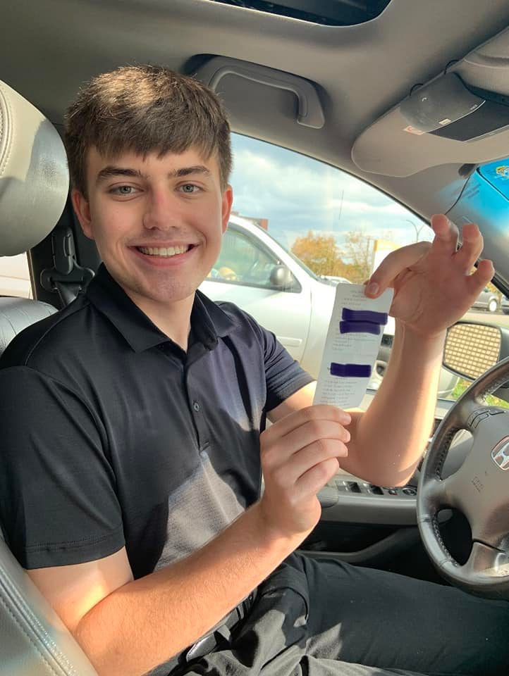 Smiling young man holding his driving test results