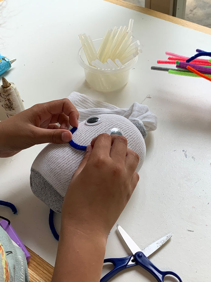 Camper making a "sock buddy" in arts & crafts
