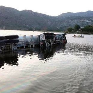 Tráilero arriesgo de más y termino volcado en presa de Metztitlán