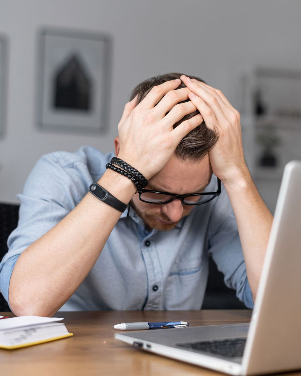 Firing staff. Employer Direct. Man with head in hands.