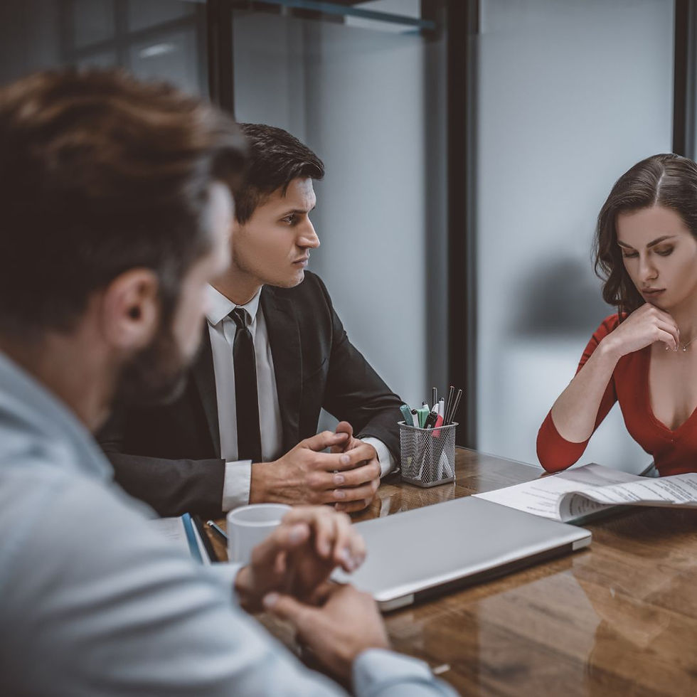 Mediation.  3 people sitting at a table reviewing documents.  