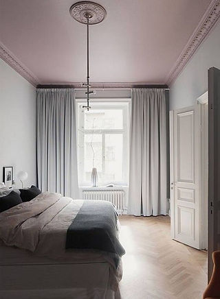 Chambre à coucher au plafond rose poudré et rideaux gris clair