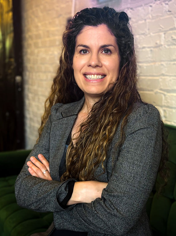Headshot of Mollie Berliss, Mediator, female in a suit with long curly brown hair